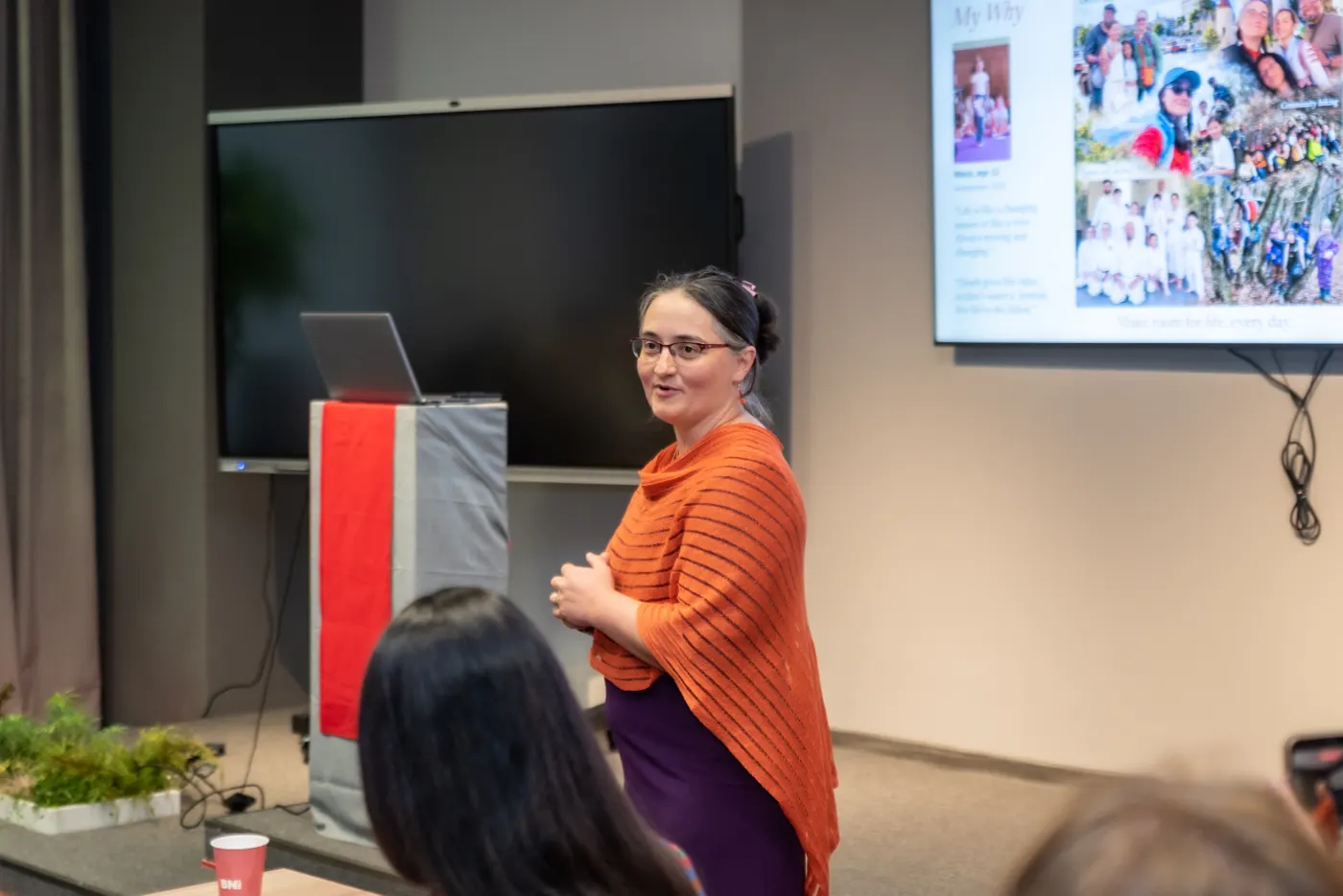 Oana Garcia smiling toward the audience while speaking at a workshop